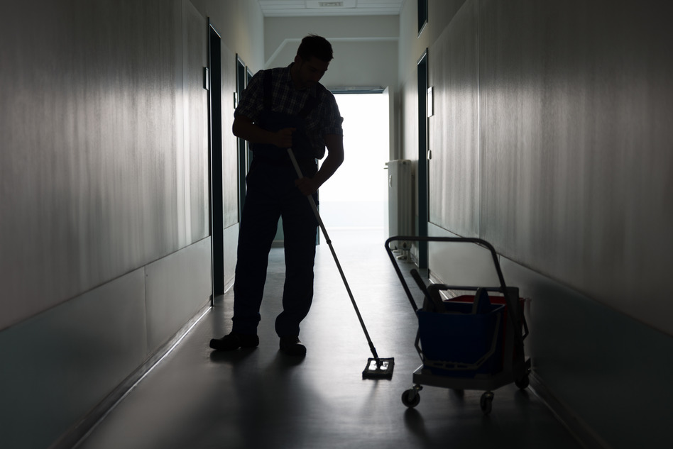 Man With Broom Cleaning Office Corridor